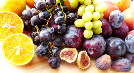 Slices of orange and fig fruits, grapes and plumsの写真素材