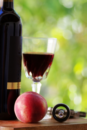 ripe peach on table.A glass of red wineの写真素材