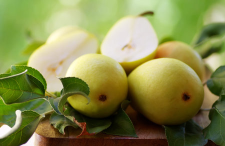 ripe pears with leaves on wooden table