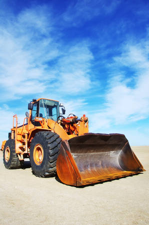 Orange loader bulldozer with cloud skyの写真素材