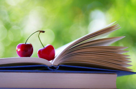 Two ripe cherries in open book