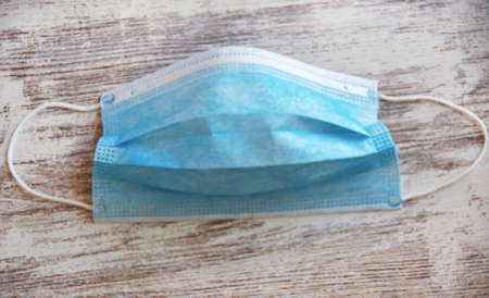 Medical mask or surgical earloop mask isolated on wooden backgroundの写真素材