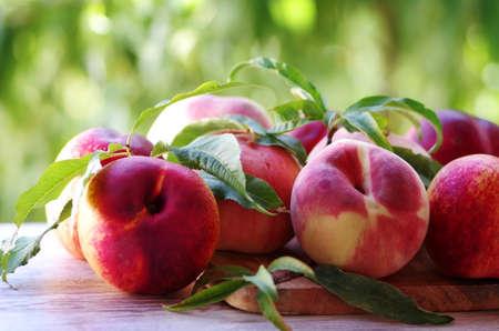 ripe peaches on wooden table, green backgroundの写真素材