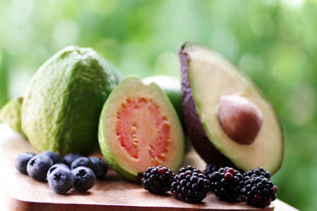 closeup of blackberry and blueberry fruits, green backgroundの写真素材