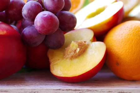 closeup of sliced peach and grapes on tableの写真素材