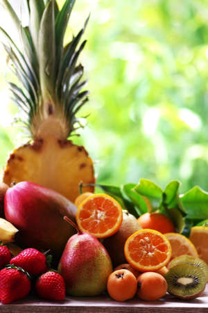 assorted fruits on the table on green backgroundの写真素材