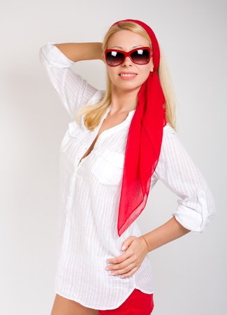 Fashion portrait of sexy woman wearing sunglasses in red scarf around headの写真素材