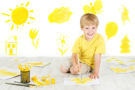 Happy child drawing with yellow color brush. Creativity concept.の写真素材