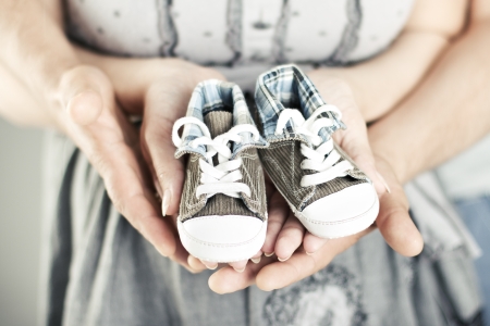 Newborn baby booties in parents hands. Close up.の写真素材