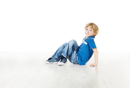 Smiling little boy sitting down on floor and looking at cameraの写真素材