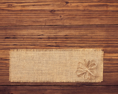 Sackcloth tag over brown wooden board backgroundの写真素材