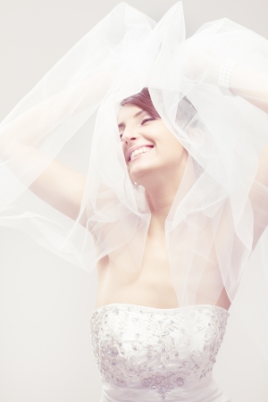 Happy bride smiling, closed eyes, carefree dreaming. Over whiteの写真素材