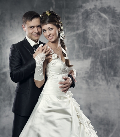 Bride and groom at gray grunge background. Wedding couple fashion shoot.の写真素材