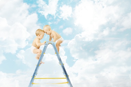 Baby climbing on stepladder and fighting  for first place over sky background  Competition conceptの写真素材