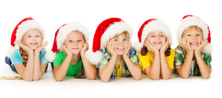 Group of happy Christmas kids in Santa hat lying down. White background.
の写真素材