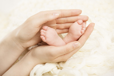Newborn baby feet mother holding in hands  New born and parentの写真素材
