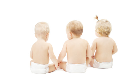 Baby friends in diapers sitting over white isolated background. back side viewの写真素材