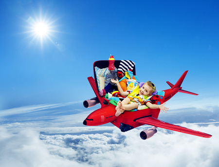Airplane Travel, Baby Kid Packed Suitcase, Child Flying inside Luggage Plane to Holiday Vacation over Blue Skyの写真素材