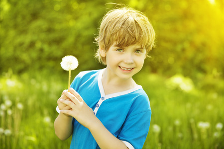 Child Portrait Outdoor with Dandelion, Little Boy Fashion Beauty Face, Kid six years old posing over Green grassの写真素材