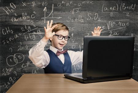 Kid Looking at Laptop, Child with Notebook, Little Boy Mathematics Formula on Chalkboard Kid Looking at Laptop, Child with Notebook, Little Boy Mathematics Formula on Chalkboard