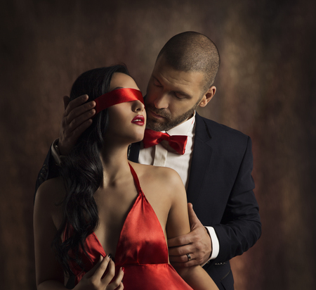 Sexy Couple Love Kiss, Man in Suit Kissing Sensual Woman, Red Fashion Blindfold on Girl Eyesの写真素材