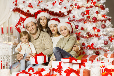 Christmas Family Portrait, Happy Father Mother Teenager Child and Baby With Presents Gifts, Decorated Xmas Tree in Red White Colorsの写真素材