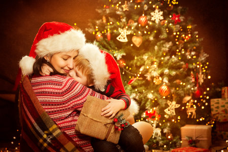 Christmas Family and Xmas Tree, Happy Mother give Baby Child New Year Present Giftの写真素材