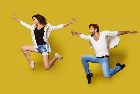 Jumping Couple, Full Length Profile Young People in Sport Dance, Isolated Yellow Background