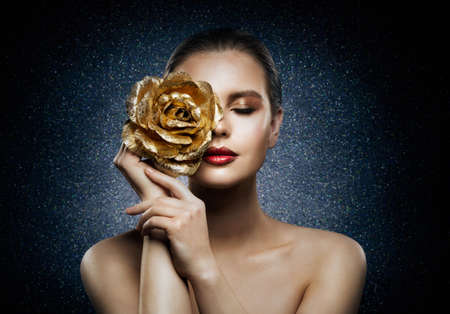 Woman Face Skin Care Flower Gold Mask. Beautiful Fashion Girl with Rose Jewelry on Face. Night Treatment Product. dark Blue Backgroundの写真素材