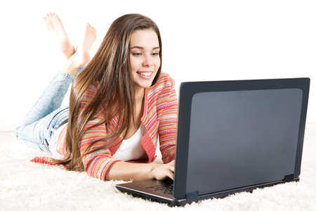 Happy Woman working on Laptop. Young Girl typing on Computer Keyboard. Woman looking at Screen and write over White Backgroundの写真素材