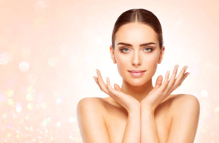 Perfect Skin Face Woman Portrait. Beauty Model with open Hands under Chin over Bright Shining Beige Background. Skin Care Cosmetic Cosmetologyの写真素材