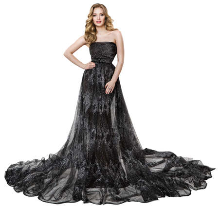 Fashion Model in Long Black Dress. Stylish Woman with Perfect Curly Hairstyle and Make up in Sparkling Holiday Luxury Gown over Isolated Whiteの写真素材