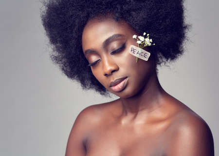 Black Woman Peace Concept. African Women Model Portrait with Adhesive Plaster on Face and White Flower Power Treatment. Stop Warの写真素材