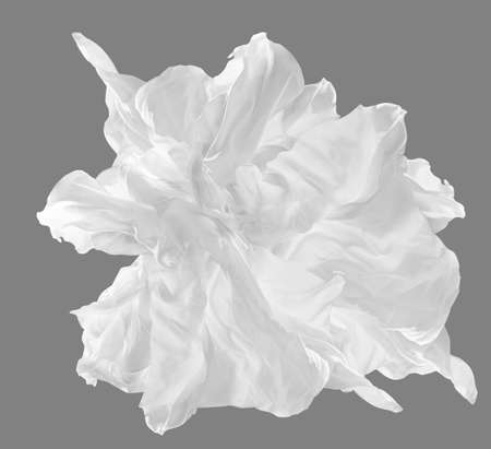 White Silk Fabric Flying on Wind. Chiffon Scarf waving in Air over Gray Background. Creative Snowy Satin Textile Object fluttering as Flower Artの写真素材