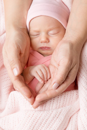 Baby Hand in Mother Palms. Newborn Girl sleeping with Blanket. Mum Love and Parents Care Concept. Infant Child Face Close up Portrait in Mother&#39;s Handsの写真素材