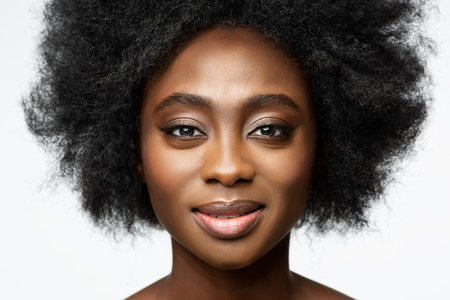 African Woman close up Portrait over White. Dark Skinned Beauty Model with Afro Hairstyle and Natural Makeup. Women Face Skin Care and Cosmetologyの写真素材