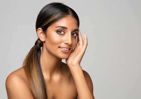 Beauty Girl Face Care. Beautiful Model Perfect Smooth Skin Makeup over White. Indian Woman Facial Cosmetology. Women Hair and Body Spa Treatment Cosmeticsの写真素材