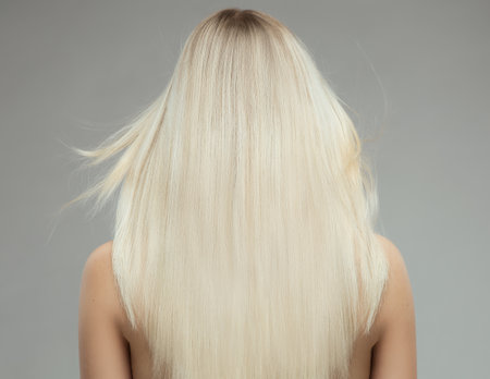 Blond Hair Woman Rear View over isolated Gray. Blondie Girl with Long Straight Hairstyle Back Side. Shiny Smooth Blond Hair Close upの写真素材