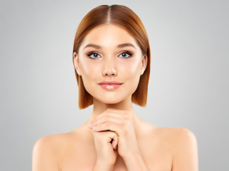 Beauty Face care. Red Hair Girl with Full Lips and smooth Makeup. Women Facial Dermal Filler Cosmetology and Health Skin Aesthetic Care. Beautiful model over isolated backgroundの写真素材