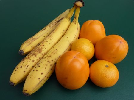 persimmon fruits, bananas and tangerinesの写真素材