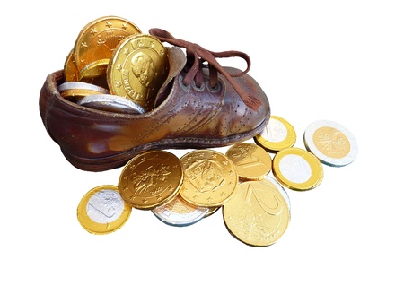 Euro coins of chocolate in a children shoeの写真素材