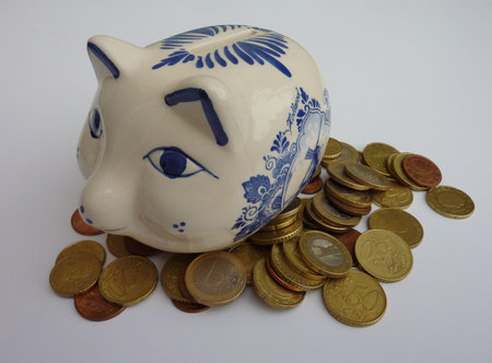 A delft blue piggy bank with euro coins