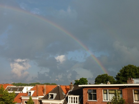 A rainbow above houses in a cityの写真素材