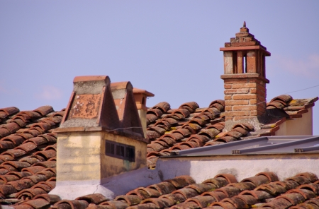 Red tiles and chimneys on a roof in Arezzoの写真素材