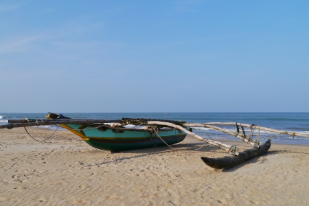 A traditional fishing boat on the beach in Sri Lankaの写真素材