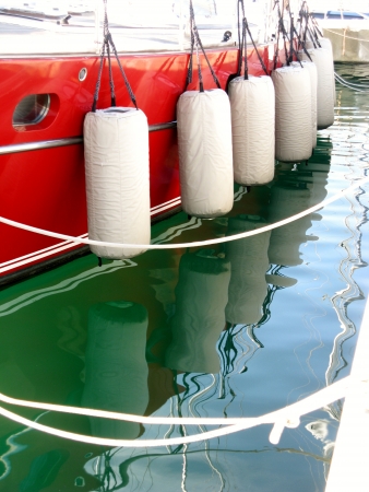 A red sailing yacht with fenders in a marinaの写真素材