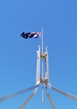 The Australian flag half mast on the Parliament building in Canberra on the day of Mandela memorial service at 10 december 2013の写真素材