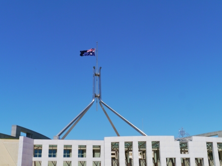The Australian flag half mast on the Parliament building in Canberra on the day of Mandela memorial service at 10 december 2013の写真素材