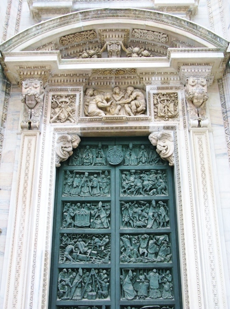 A detail of the bronze door of the gothic cathedral of Milan in Italyの写真素材