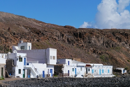 The bay and the white houses of the fishing village Pozo Negro at the Atlantic ocean on the Island Fuerteventura belonging to Spainの写真素材